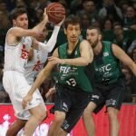 El alero del Real Madrid, Rudy Fernández (i), controla la pelota ante la oposición de José Ignacio Nogués (c), del Joventut, durante el partido
