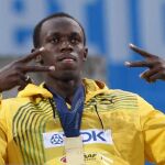 El atleta jamaicano Usain Bolt posa en el podio con la medalla de oro