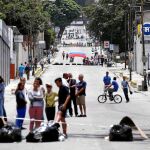 La Guardia Nacional Bolivariana detiene a una manifestante de la oposición durante una de las protestas que se sucedieron ayer en Caracas