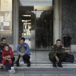 Un grupo de personas espera ante la puerta de la estación de tren de Atenas