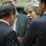 La primera ministra británica Theresa May conversa con el presidente francés François Hollande