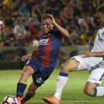 El centrocampista del Huesca, Samuel Sáiz, controla el balón junto un jugador del Getafe.
