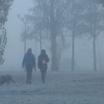 Dos mujeres pasean a sus perros bajo la niebla, frío y helada en Ponferrada