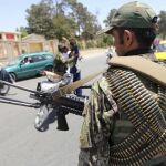 Agentes de seguridad afganos permanecen en guardia en una carretera tras el ataque suicida perpetrado ayer durante la hora del rezo contra una mezquita chií en Kabul