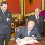 El pregonero de la Semana Santa Vicente Garrido Capa firma en el libro de honor del Ayuntamiento de Valladolid en presencia del alcalde, Óscar Puente, y presidente de la Junta de Cofradías vallisoletanas, Felipe Esteban Alonso