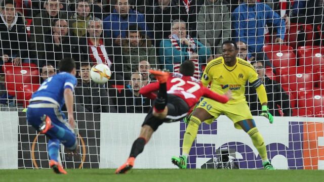 El delantero del Athletic Club Sabin Merino (c) se dispone a batir al portero del Olympique de Marsella Steve Mandanda (d)