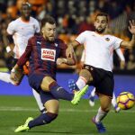 El jugador del Eibar, Sergi Enrich (i), chuta a portería en presencia del del Valencia, Martin Montoya