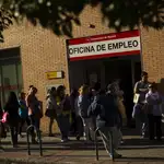 Desempleados hacen cola ante una oficina de desempleo en Madrid.
