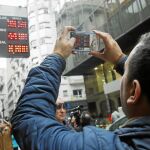 Transeúntes observan los paneles de las casas de cambio ayer en Buenos Aires. El peso argentino siguió perdiendo valor respecto al dólar. Foto: Efe