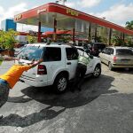 Varios venezolanos arrastran un vehículo hasta una de las pocas gasolineras de Caracas que cuentan con un generador eléctrico en medio del apagón / Reuters