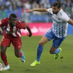 Thomas Partey se lleva el balón ante el defensa del Málaga CF, Miguel Torres.