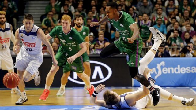 El escolta estadounidense de Unicaja Jamar Smith salta sobre el base esloveno Luka Doncic , del Real Madrid