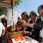 Milagros Marcos coge un pimiento de un expositor que visitó junto a la presidenta de la Diputación de Palencia, Ángeles Armisén y el alcalde Jorge Domingo González