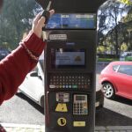 Detalle del cartel con el mensaje "alta polución. Prohibido aparcar"instalado en un parquímetro del centro de la capital