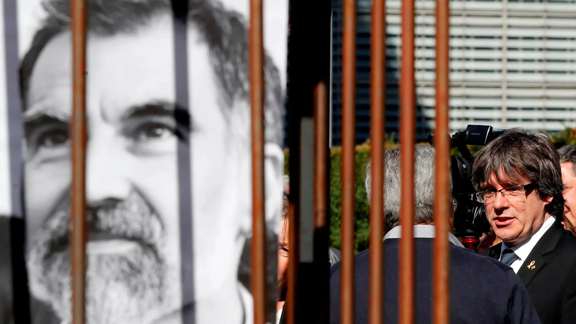 Carles Puigdemont, junto a una imagen del presidente de Omnium Jordi Cuixart