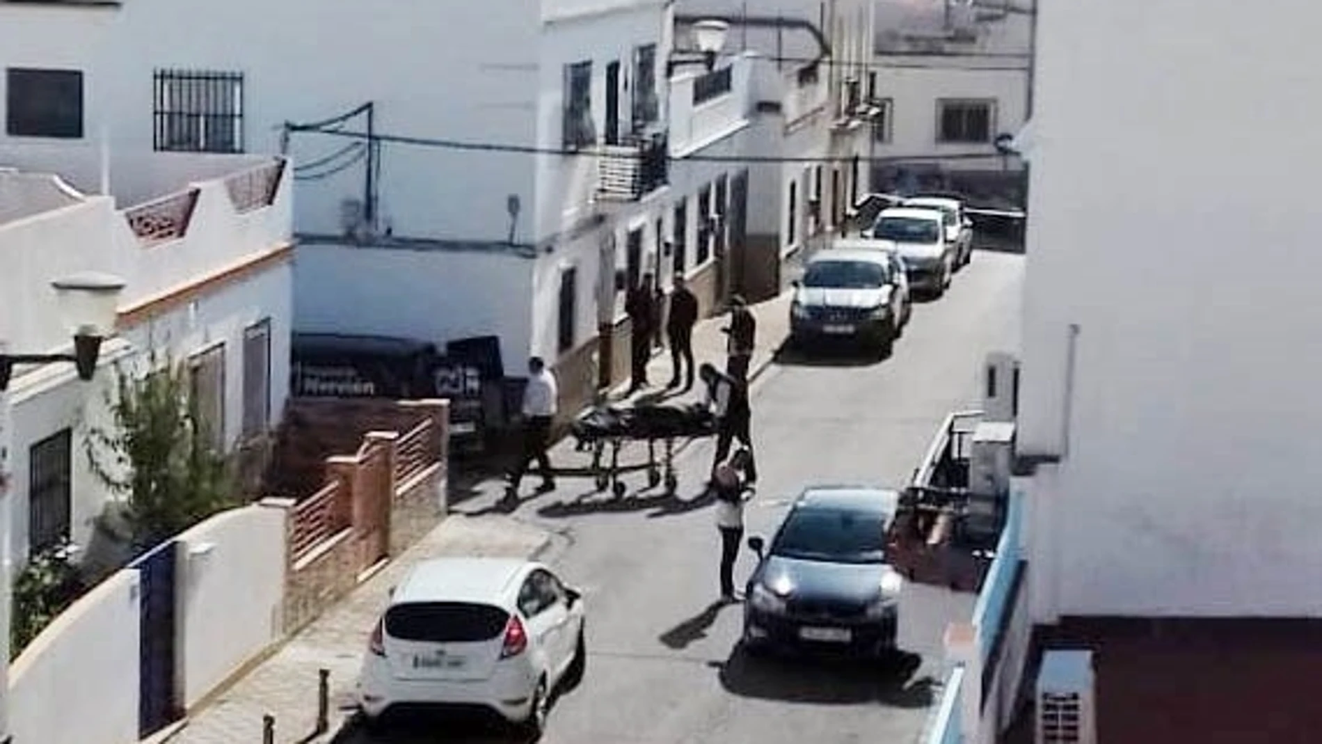 Momento en el que operarios de la funeraria sacan el cuerpo sin vida de una mujer fallecida presuntamente tras ser agredida por uno de sus hijos en la casa de planta baja ubicada en el número 8 de la calle Hilarión Eslava / Foto: Efe