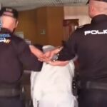 Dos policías conducen al detenido por un presunto asesinato en El Pozo (Vallecas).27/03/2019