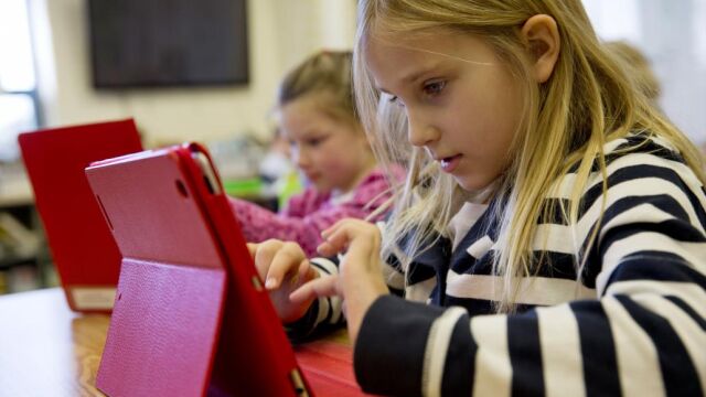 Dos niñas con un iPad en una escuela