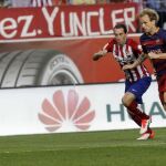 El centrocampista croata del F. C. Barcelona, Ivan Rakitic (d), disputa un balón con el defensa uruguayo del At. de Madrid, Diego Godín