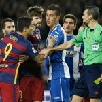 El árbitro Juan Martínez Munuera (d) muestra la tarjeta amarilla al delantero uruguayo del FC Barcelona Luis Suárez (i), durante el partido
