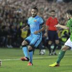 El defensa brasileño del F. C. Barcelona, Douglas Pereira (i), golpea el balón ante el delantero del Villanovense, Calatrava.