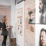 Una joven ante una de las piezas de la exposición