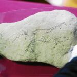 Grabación en piedra caliza de una escena de dos figuras humanas que siguen a dos grullas / Universidad de Barcelona