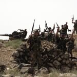 Soldados sirios hacen el signo de la victoria tras tomar el control de un territorio rebelde en la provincia sureñña siria de Al Sueida, hoy 12 de julio de 2017