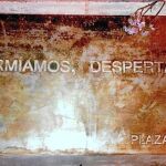 Durante el verano de 2011 los «indigandos» instalaron una placa con el lema «Dormíamos, despertamos» en el pedestal de la estatua de Carlos III en la Puerta del Sol