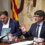 El presidente de la Generalitat, Carles Puigdemont (d), y su vicepresidente, Oriol Junqueras