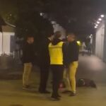 El joven desplomado en el suelo tras recibir el puñetazo por parte del hombre de la derecha que viste pantalón claro