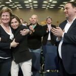 La presidenta del Parlament de Cataluña, Carme Forcadell, se abraza a la diputada Anna Simo, en presencia del líder republicano, Oriol Junqueras, durante un acto de ERC