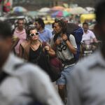 Turistas pasean por una calle de la India.