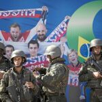 Soldados del Ejército brasileño delante de uno de los murales de Río en el que se muestra a aficionados rusos