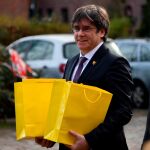 Puigdemont portando bolsas amarillas