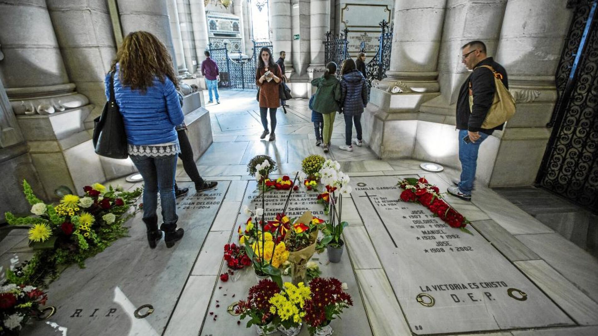 Visitantes de la catedral observan las flores depositadas en el enterramiento de la familia Franco en la catedral de la Almudena