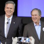 El ex presidente George W. Bush acompaña a su hermano, ayer, en un mitin