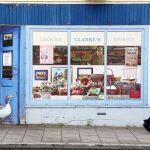 Un hombre camina por delante de una tienda vacía decorada en el pueblo de Bushmills, en Irlanda del Norte