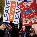 Manifestantes a favor y en contra del Brexit elevan sus pancartas, en Londres, antes de la votación