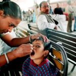 Una mujer suministra la vacuna contra la polio en India