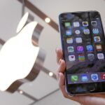 Un cliente muestra un iPhone 6 plus en una tienda Apple de Tokio, Japón.