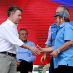 El presidente de Colombia, Juan Manuel Santos (i), estrecha la mano del máximo líder de las FARC, Rodrigo Londoño, alias Timochenko (d)