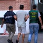 Imagen de dos guardias civiles custodiando a uno de los detenidos