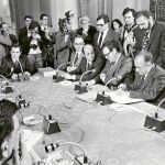 La mesa de negociaciones de los Pactos de la Moncloa. De izquierda a derecha: Adolfo Suárez, Fernando Abril Martorell, Francisco Fernández Ordoñez, Ramón Tamames, Santiago Carrillo, Tomás García (Juan Gómez) y Jordi Solé Tura. En el lado izquierdo, parcialmente, Felipe González.