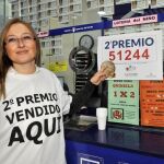 La responsable de la administración nº 20 de Albacete muestra el cartel del segundo premio del Sorteo Extraordinario de la Lotería de Navidad, el 51.244