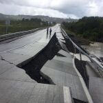 Personas caminan por una carretera destruida en Tarahuin, en la isla de Chile