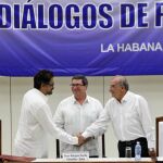 El segundo jefe de las FARC y líder de los delegados de la guerrilla, Luciano Marín (i), alias "Iván Márquez"; saluda al jefe de la delegación de paz del Gobierno colombiano, Humberto de la Calle (d); junto al canciller cubano, Bruno Rodriguez (c)