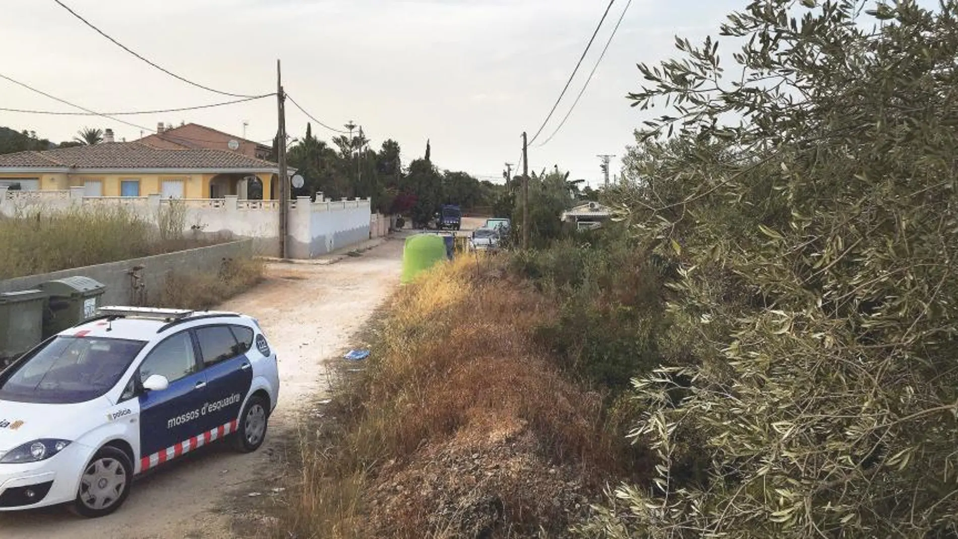Un coche de los Mossos D’Esquadra, ayer, en la urbanización de Alcanar en la que explotaron las bombonas de los terroristas. En la otra página, estado en el que quedó la vivienda