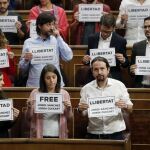 Diputados nacionalistas y de Unidos Podemos muestran carteles pidiendo la libertad de los responsables de las organizaciones ANC y Ómnium Cultural