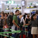 Los pasajeros hacen cola para pasar el control de seguridad.